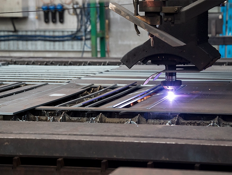 Steel laser machine cutting steel plate inside a warehouse